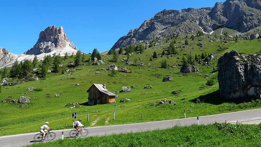 Twee fietsers op een weg in een berglandschap
